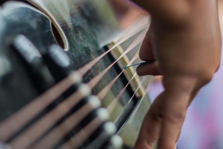 Close-up of fingers plucking guitar strings