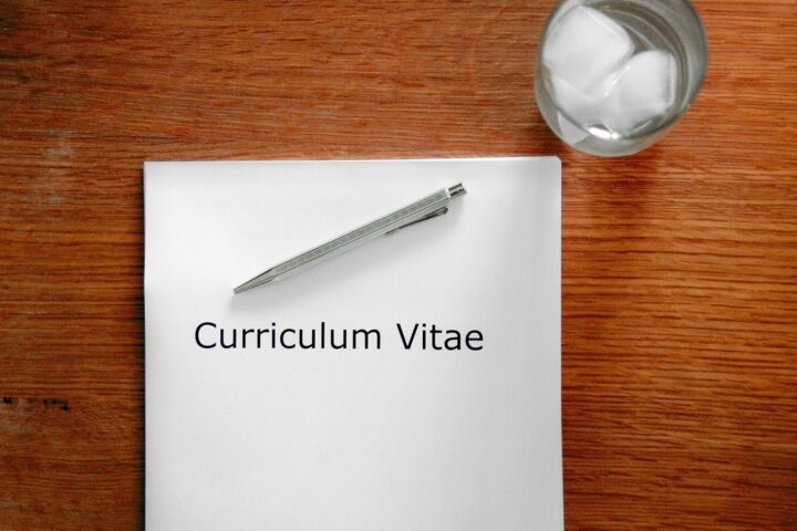 Sheet of paper titled Curriculum Vitae with a pen on a desk