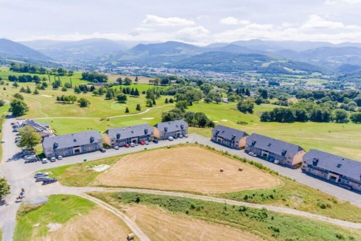 Aerial view of a golf course and resort buildings in the Pyrenees foothills