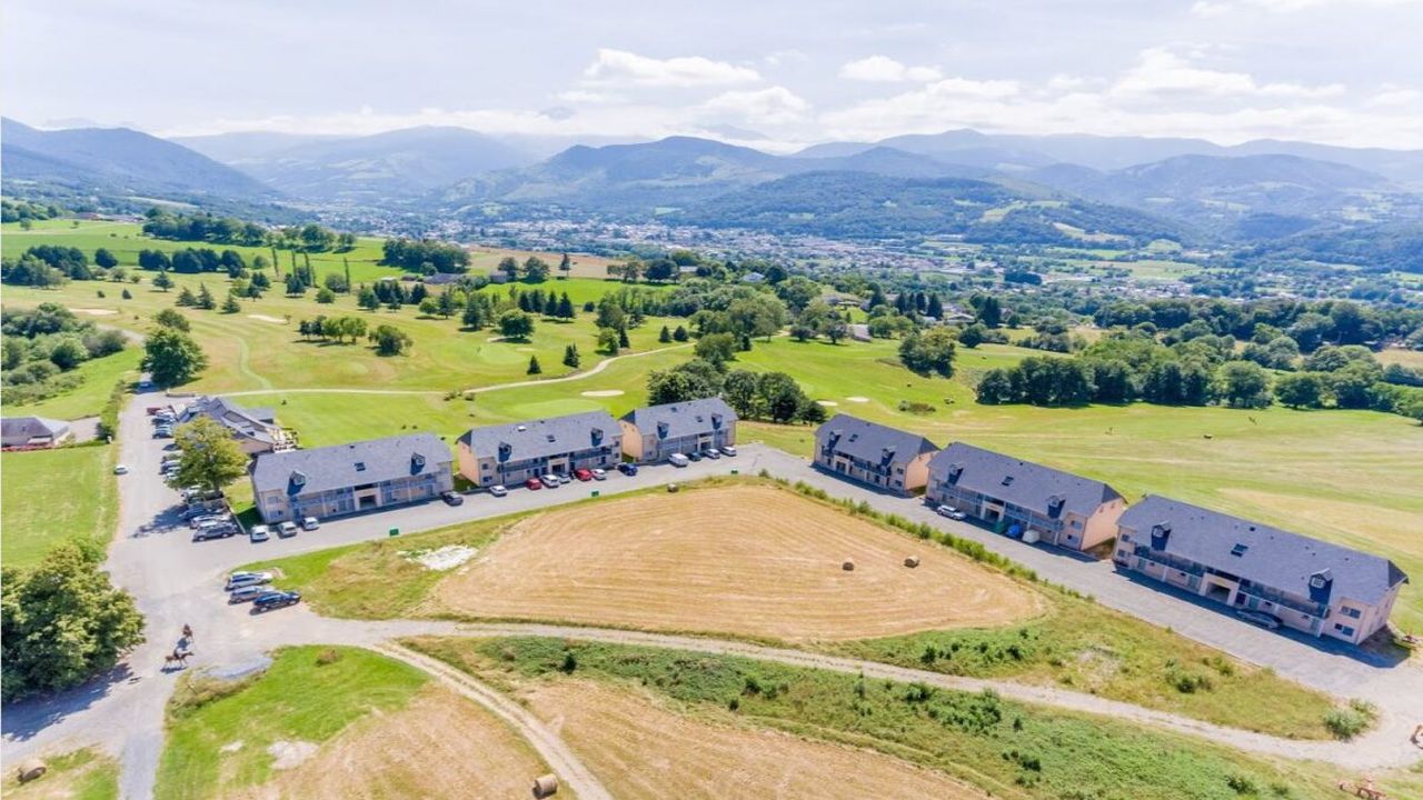 Aerial view of a golf course and resort buildings in the Pyrenees foothills
