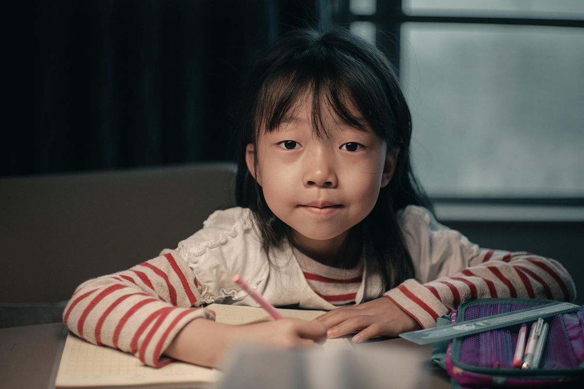 Young girl looking thoughtful at her desk