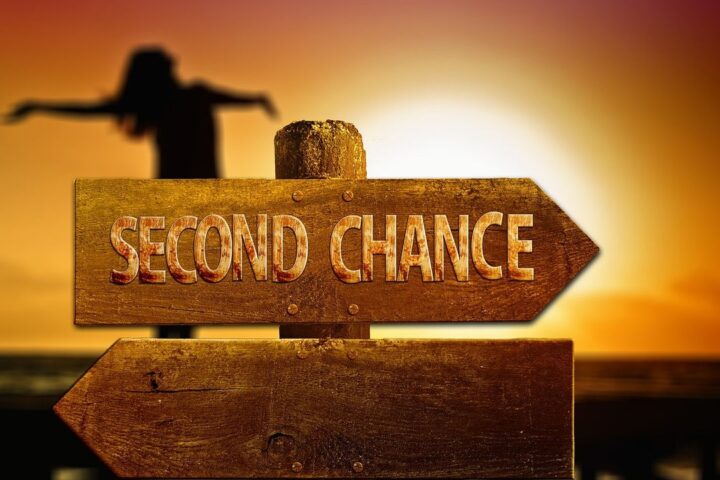 Signpost reading Second Chance against a sunset