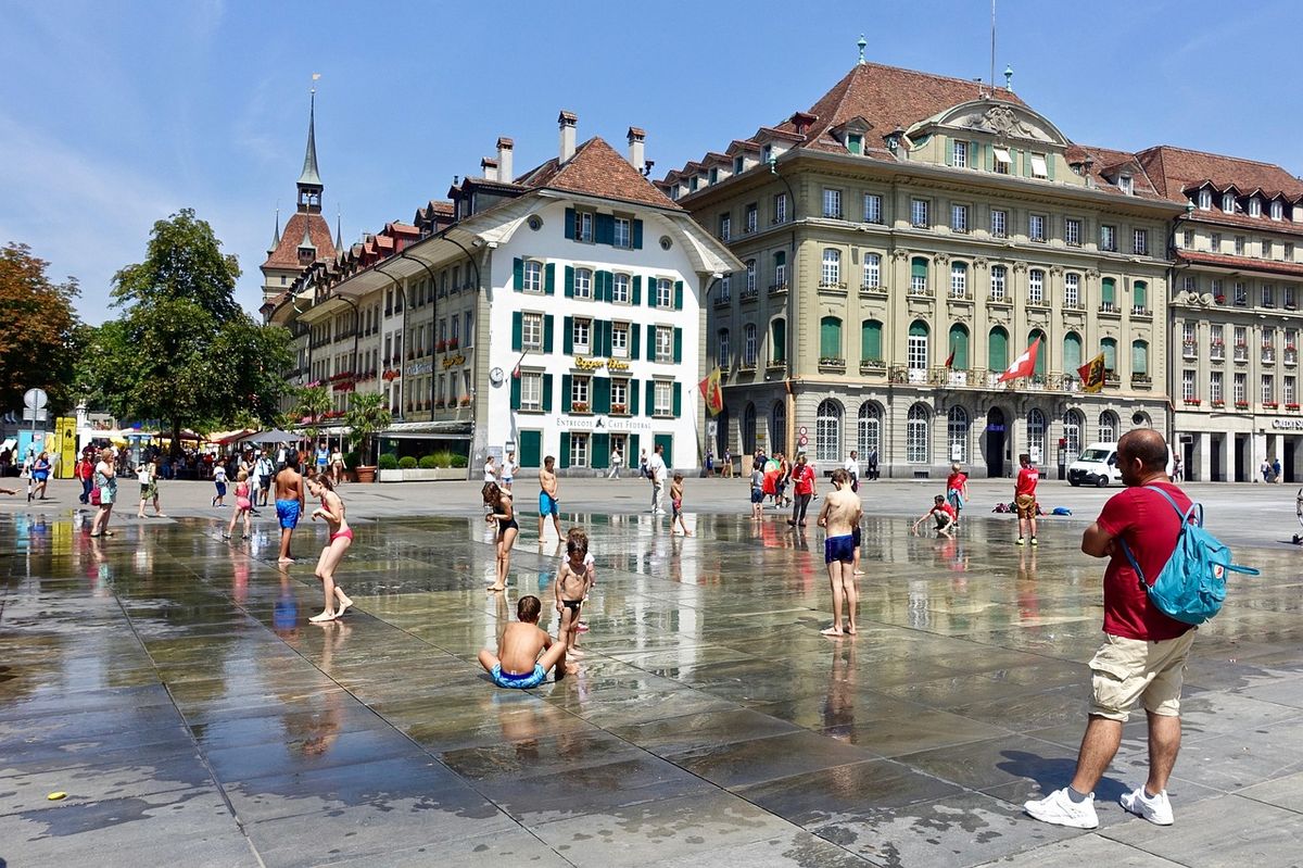 Children playing in fountains in a town square