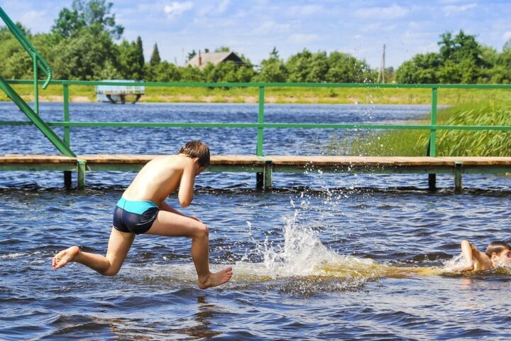 Boy jumping into a lake on a summer day