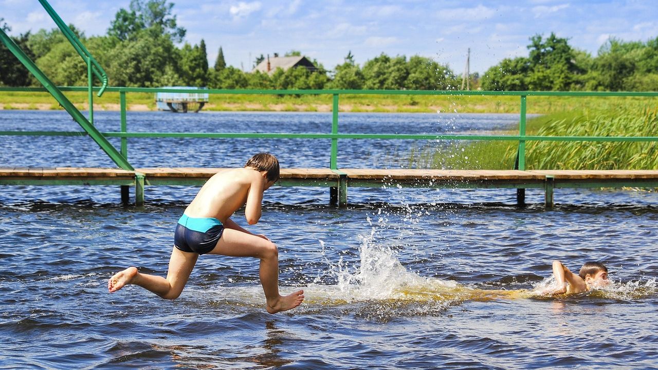 Boy jumping into a lake on a summer day