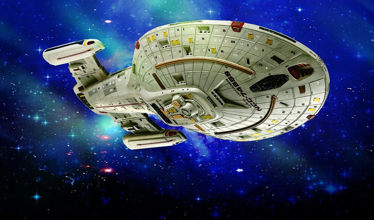 Model starship against a starry galaxy background