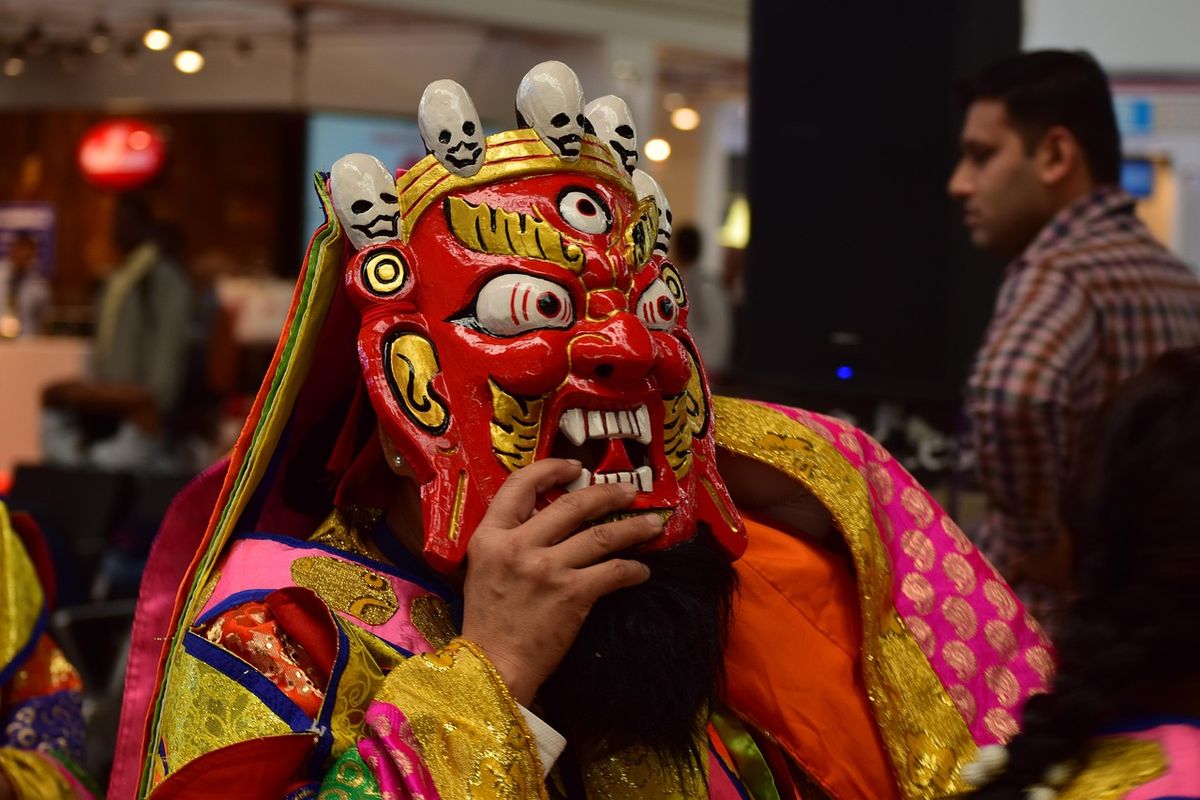 Performer in a red demon mask at a cultural festival