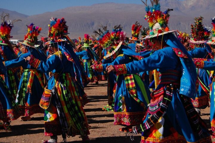 Dancers in colourful feathered costumes at a festival