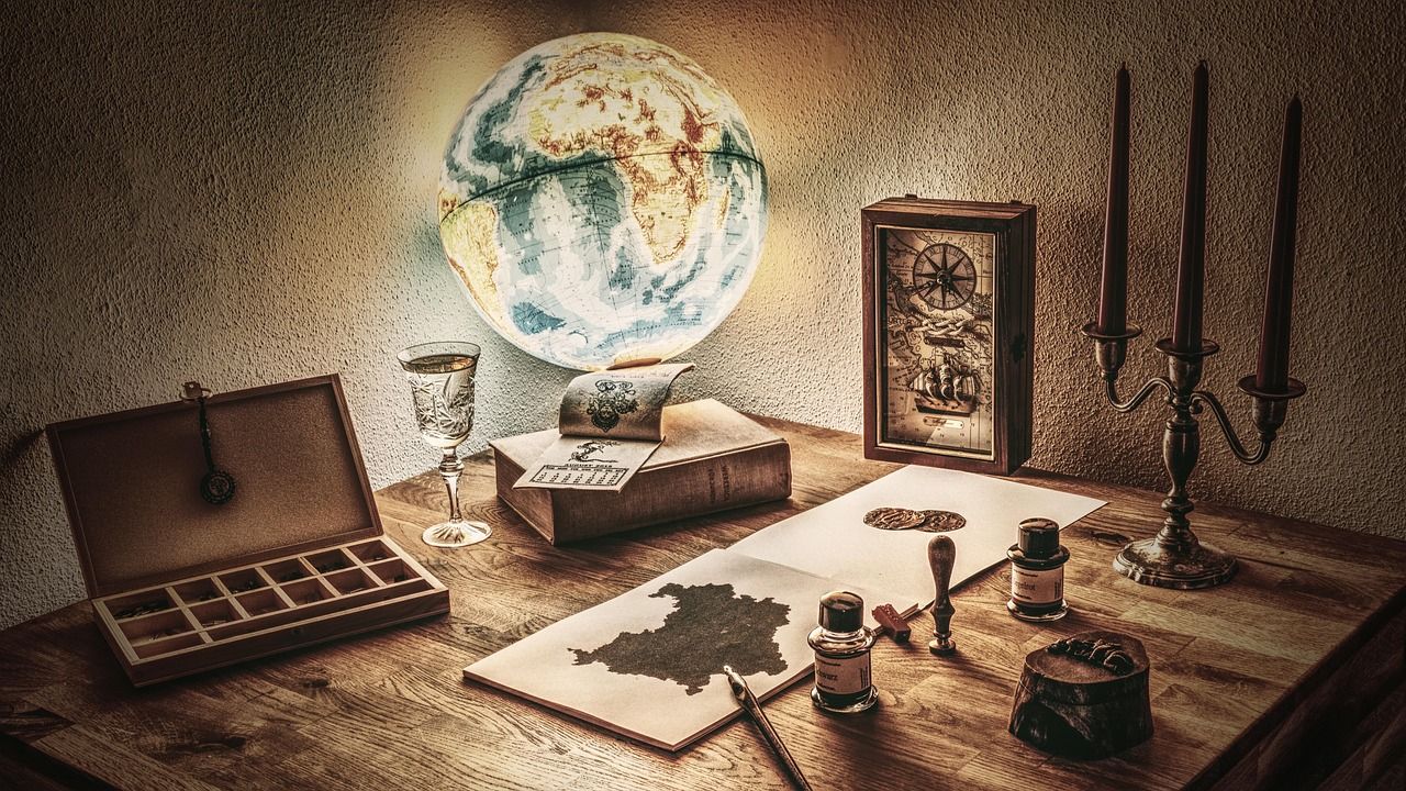Old-fashioned desk with a globe, inkwells, clock and candlesticks