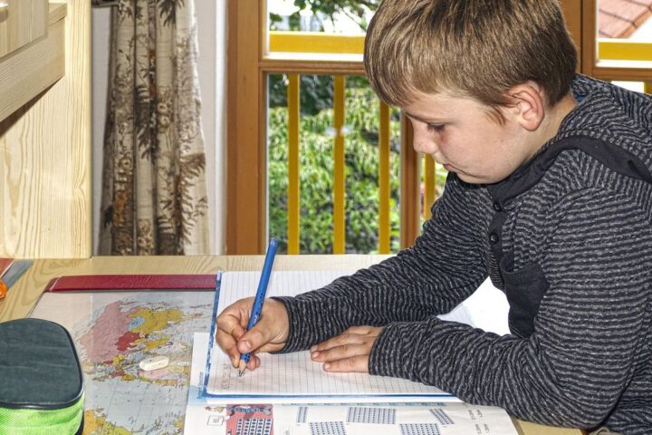 Boy concentrating on writing at a desk