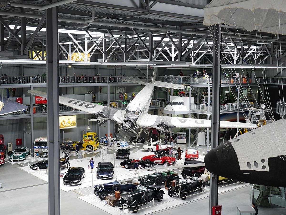 Museum hall filled with vintage aircraft and cars
