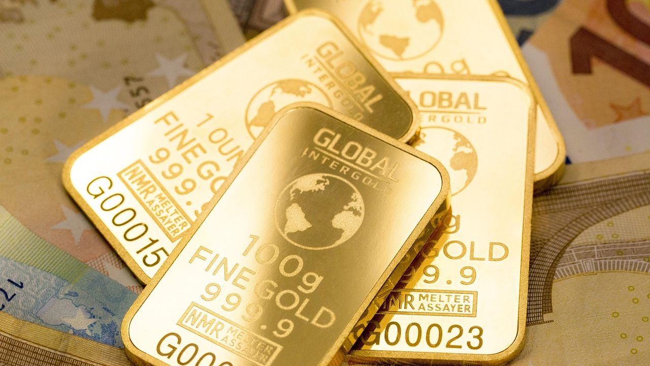 Stack of 100g fine gold bars on banknotes