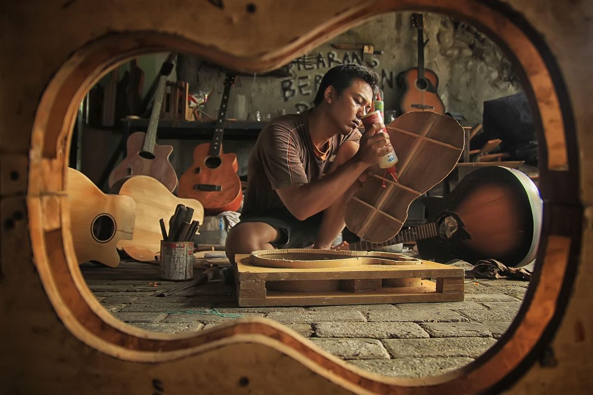 Craftsman building a guitar in his workshop