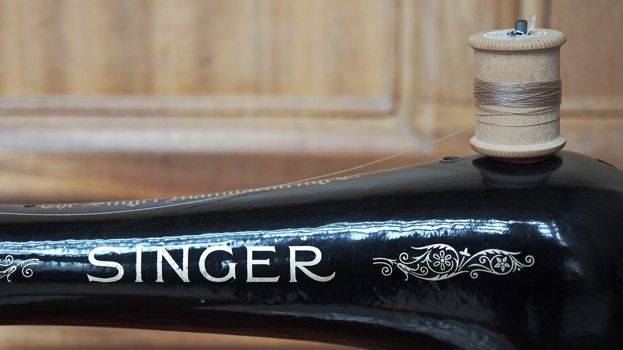 Close-up of a vintage Singer sewing machine with thread