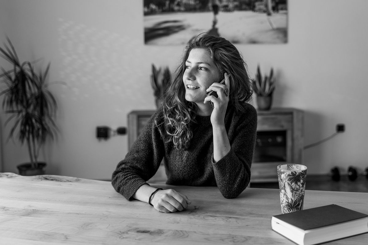 Woman laughing on the phone at her desk