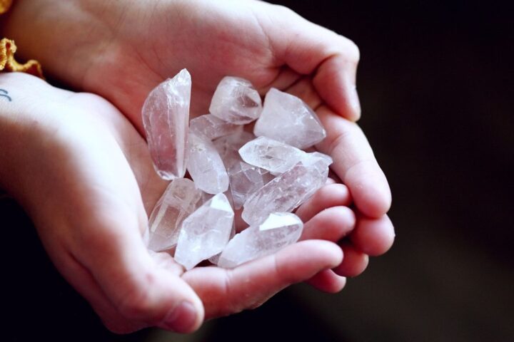 Cupped hands holding clear quartz healing crystals