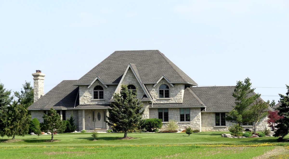 Grey-roofed country house surrounded by trees