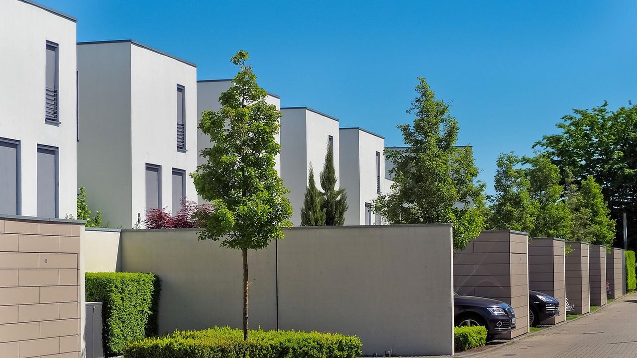 Row of modern white townhouses on a quiet street