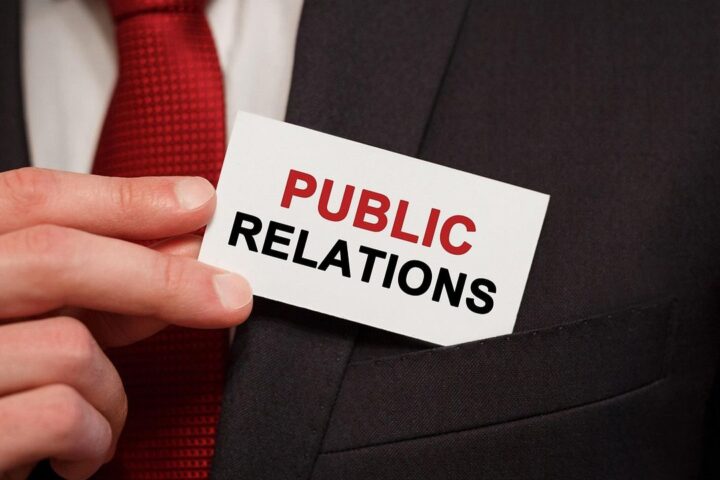 Hand holding a card reading Public Relations