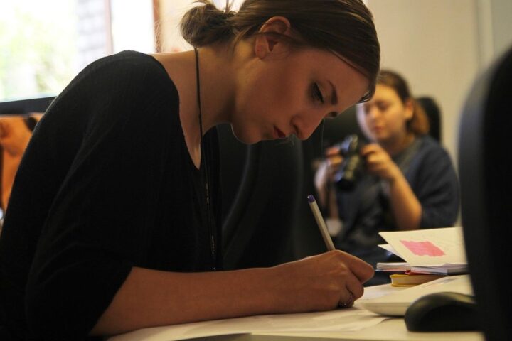 Woman sketching designs at a desk in a creative studio