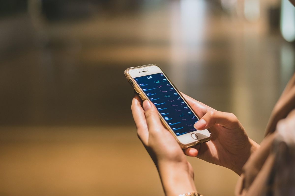 Hand holding a smartphone showing an app