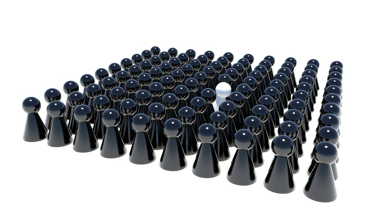 One white game piece standing out among black ones