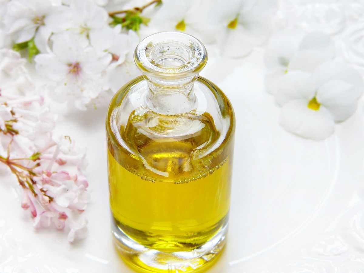 Bottle of massage oil among white blossoms