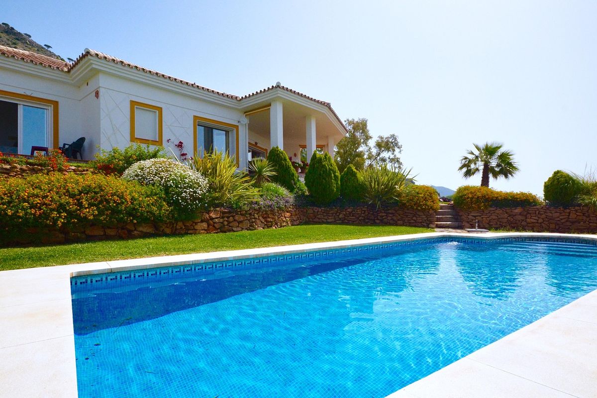 White villa with a swimming pool and palm trees