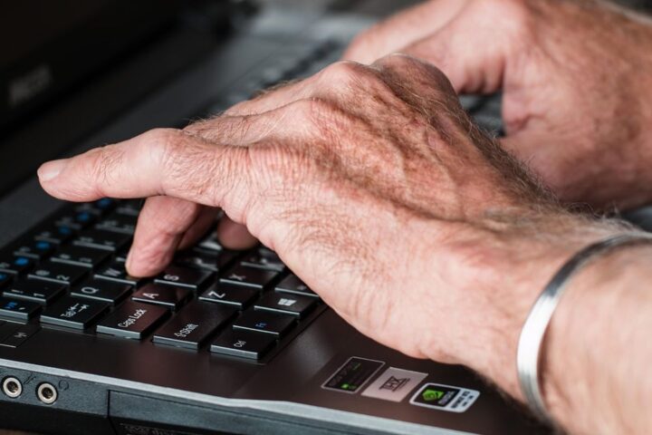 Hands typing on a laptop keyboard