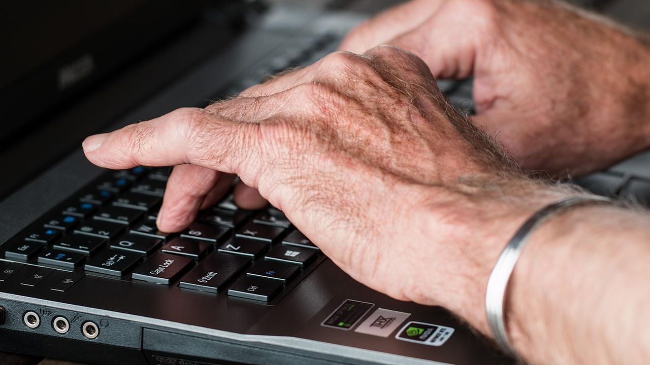 Hands typing on a laptop keyboard