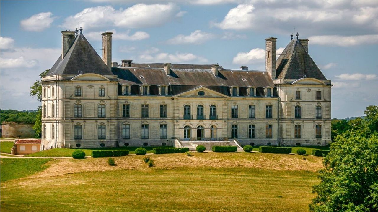 Grand French château with slate roofs above green lawns