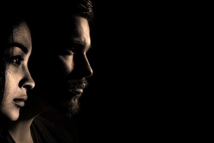 Profiles of a man and a woman in dramatic shadow
