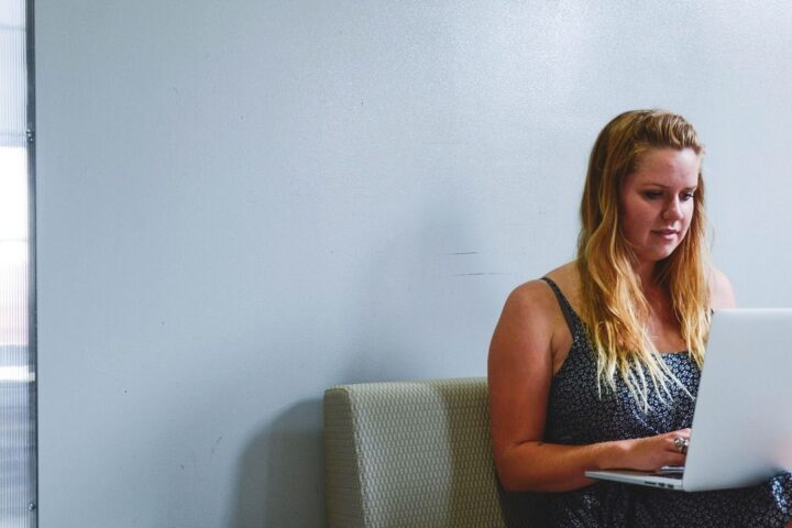 Young woman working on a laptop on a sofa