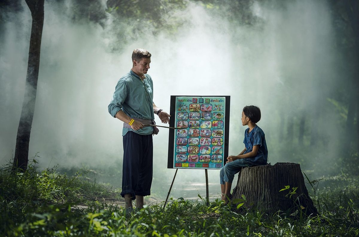 Teacher showing a chart to a pupil outdoors