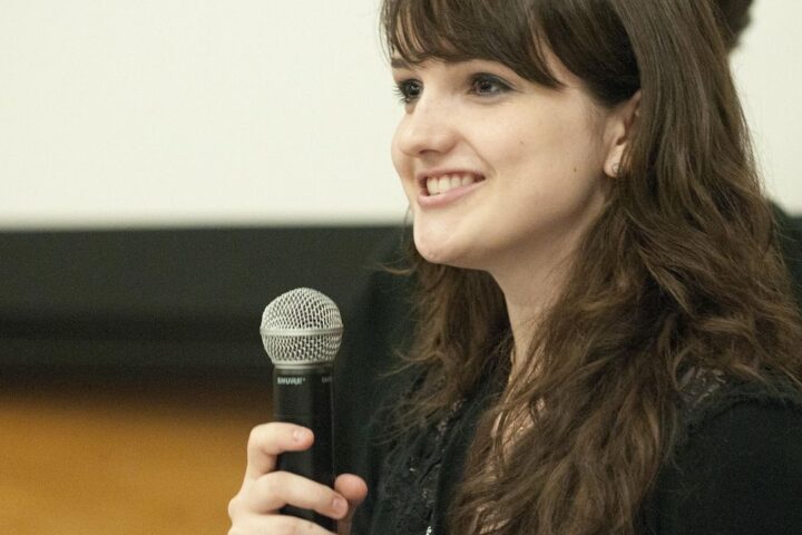 Woman speaking into a microphone at a conference
