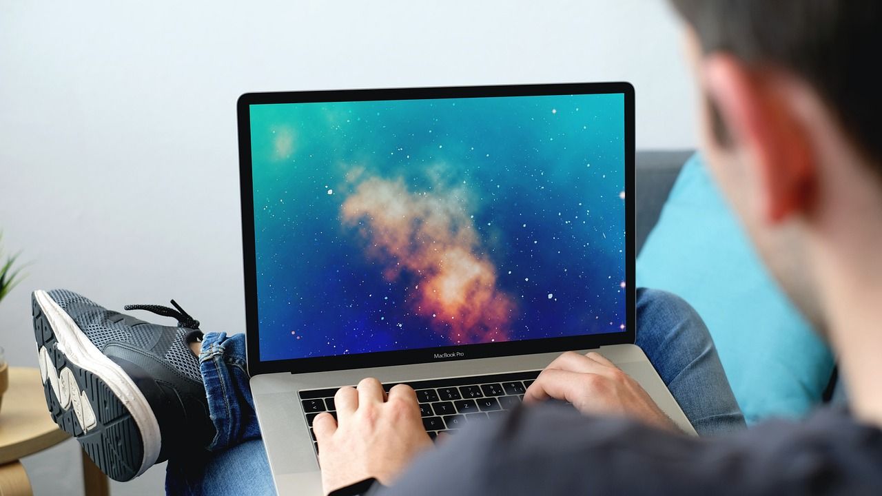 Man working on a laptop with his feet up at home
