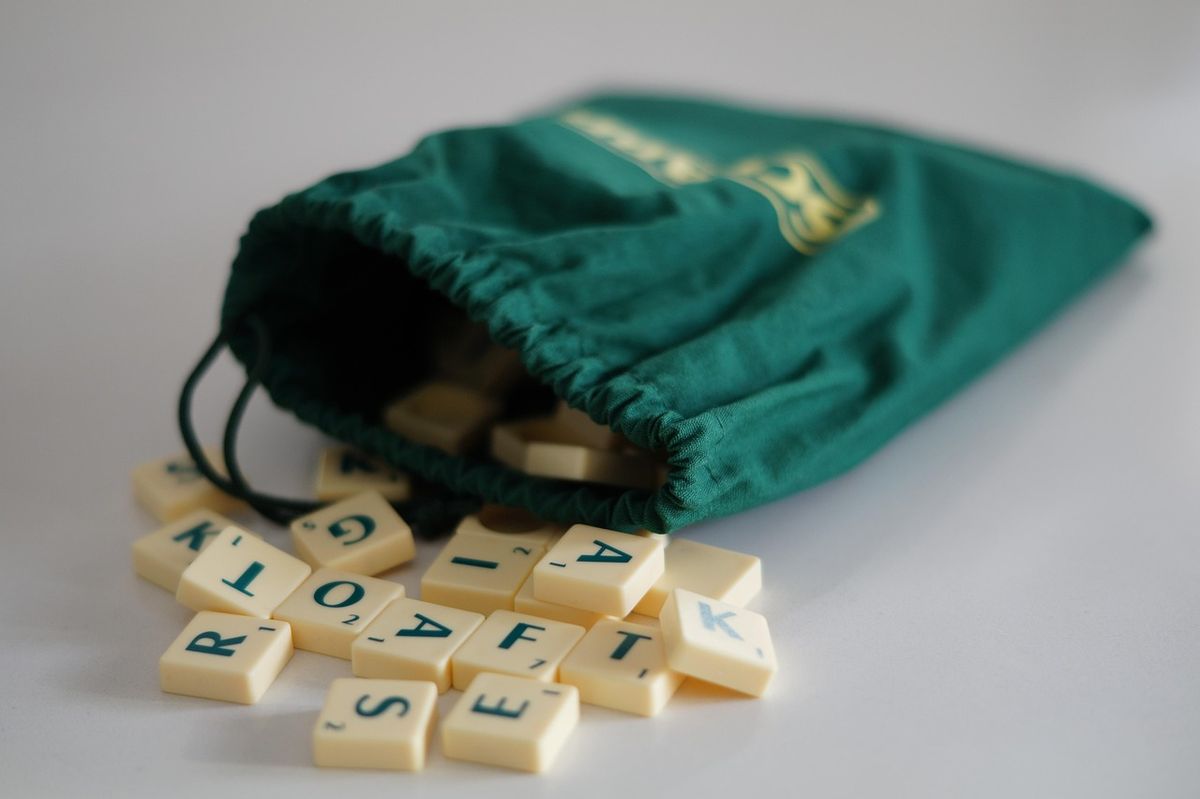 Scrabble tiles spilling from a green bag