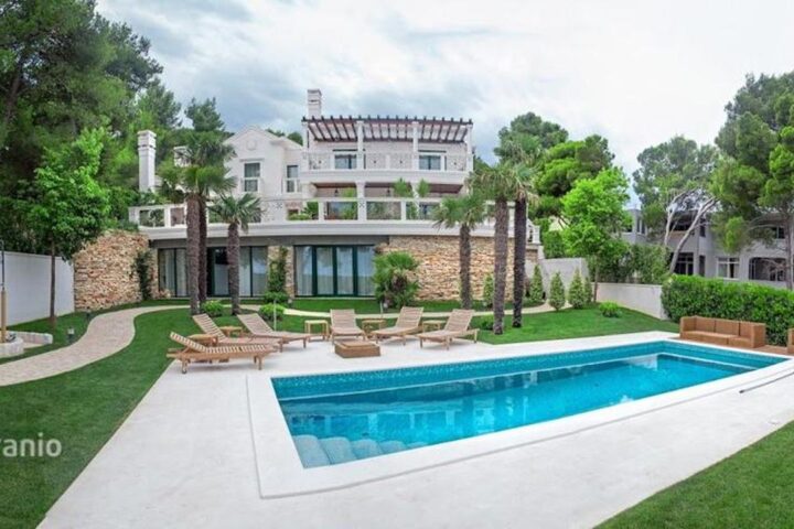 Modern villa with a pool and lawn among pine trees