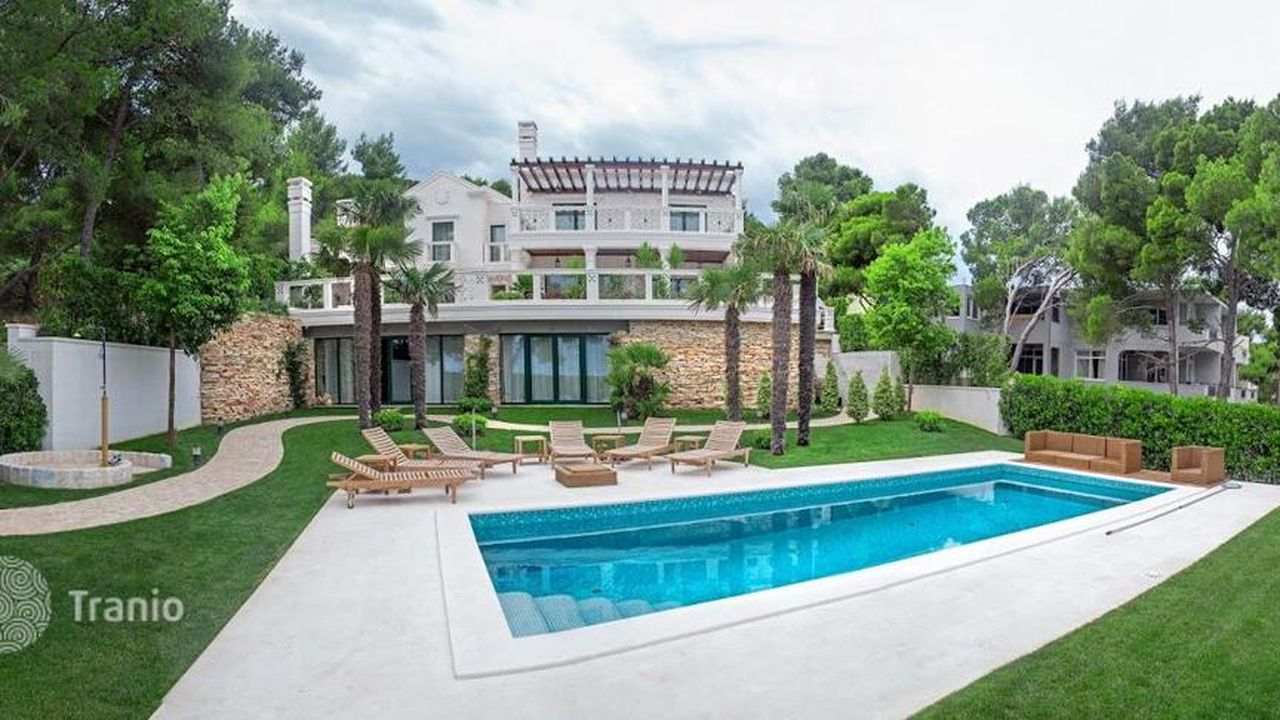 Modern villa with a pool and lawn among pine trees