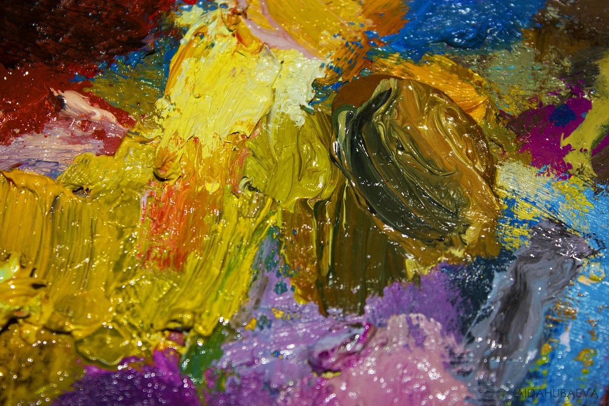 Close-up of thick swirls of yellow, red and blue oil paint
