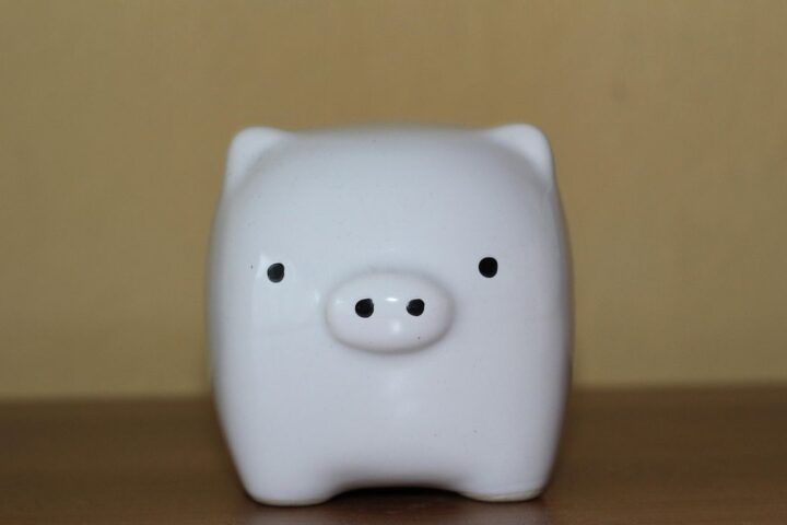 White ceramic piggy bank on a wooden table