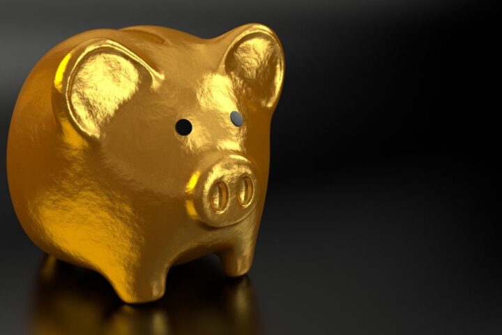 Gold piggy bank on a dark background