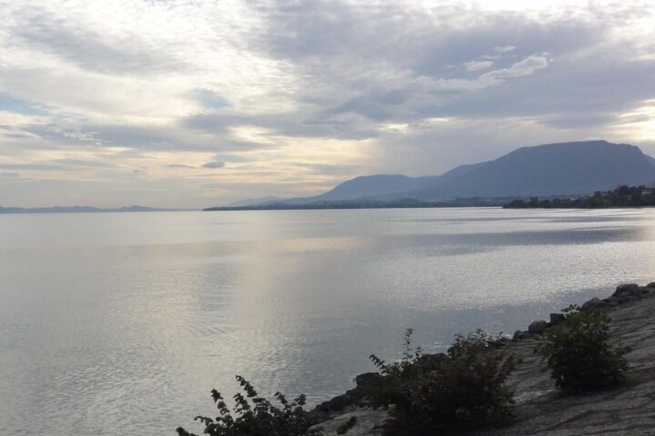 Calm lake with mountains under a cloudy sky