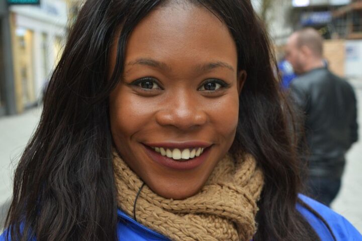 Smiling young woman in a scarf on a city street