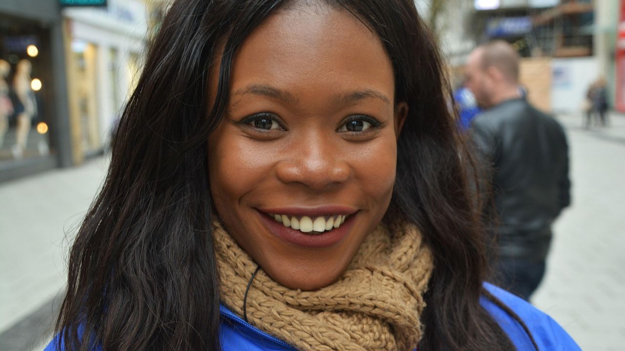 Smiling young woman in a scarf on a city street