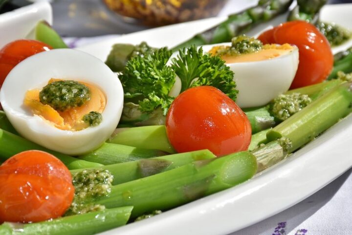 Plate of asparagus, boiled eggs and tomatoes