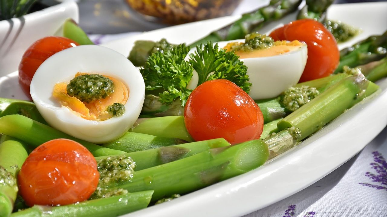 Plate of asparagus, boiled eggs and tomatoes