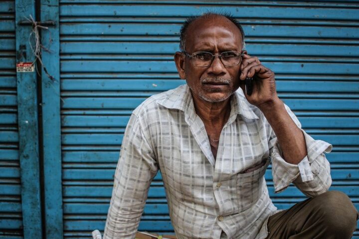 Man in a checked shirt talking on his phone
