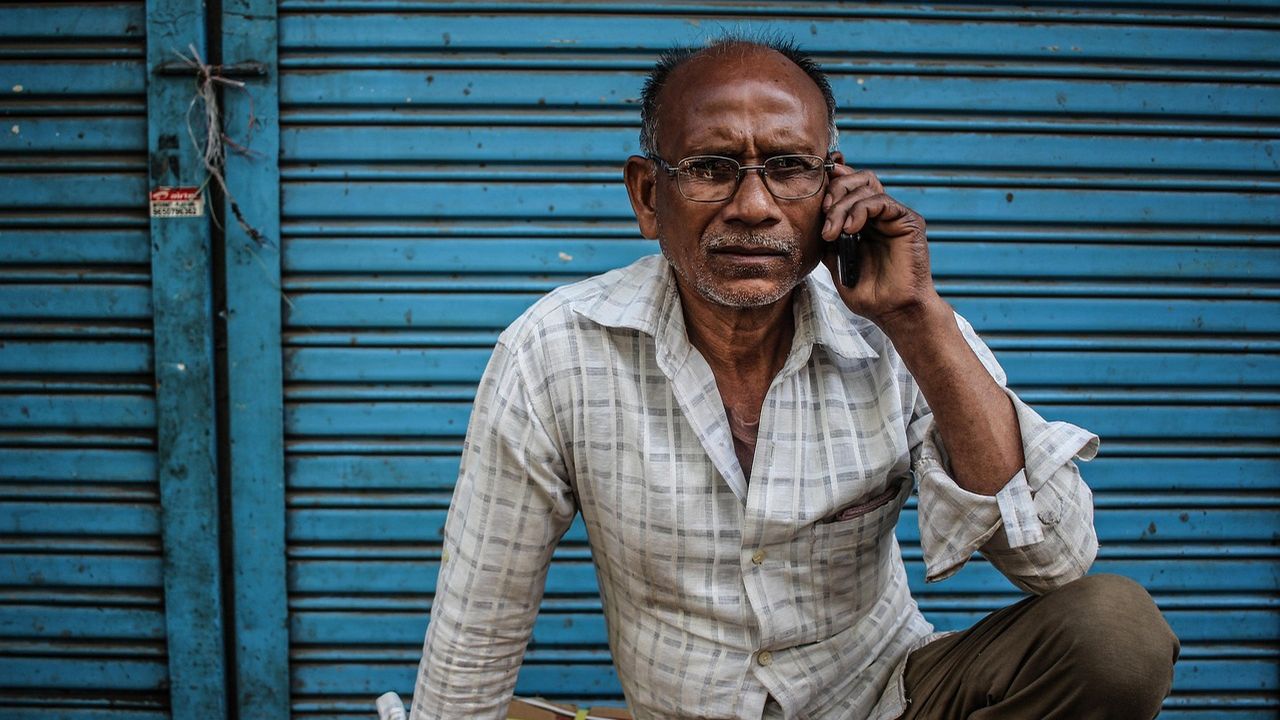 Man in a checked shirt talking on his phone