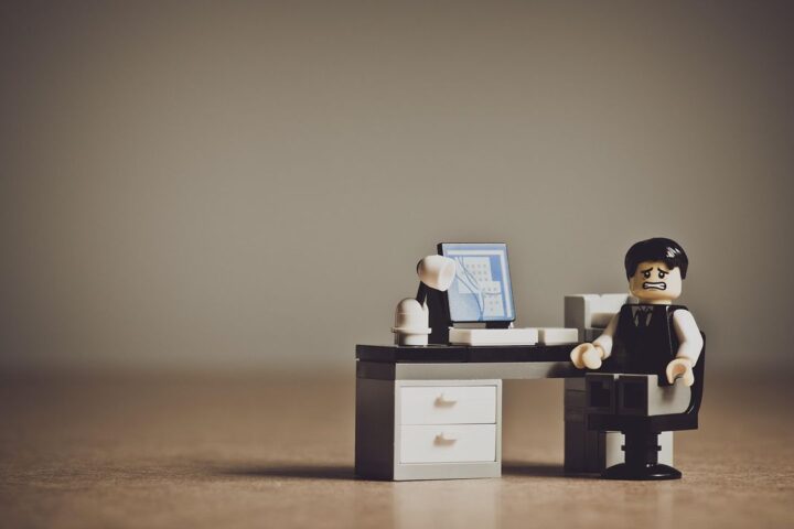 Toy office worker figure sitting at a tiny desk